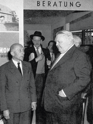 Auf der Handwerksmesse 1957 in München besucht Bundeswirtschaftsminister Ludwig Erhard den Stand des KTL und Erhard spricht mit dem ALB-Vorsitzenden Dr. Fritz von Engelberg.