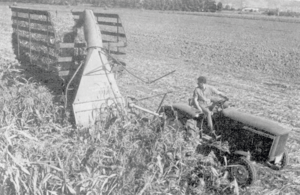 Der von einem Traktor gezogene Feldhäcksler erntet Mais und bläst ihn direkt auf den Ladewagen.