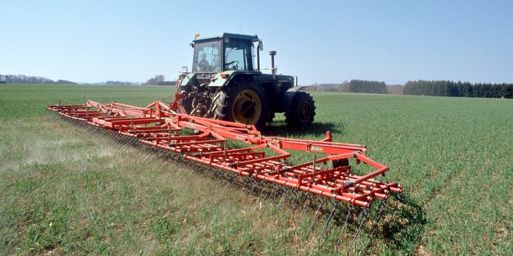 Traktor mit Anbaugerät auf dem Feld - Foto