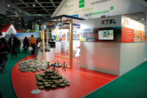 Auf dem KTBL-Stand auf dem Erlebnisbauernhof der „Grünen Woche“ sind auf dem roten Fussboden verschiedene Feldroboter ausgestellt.